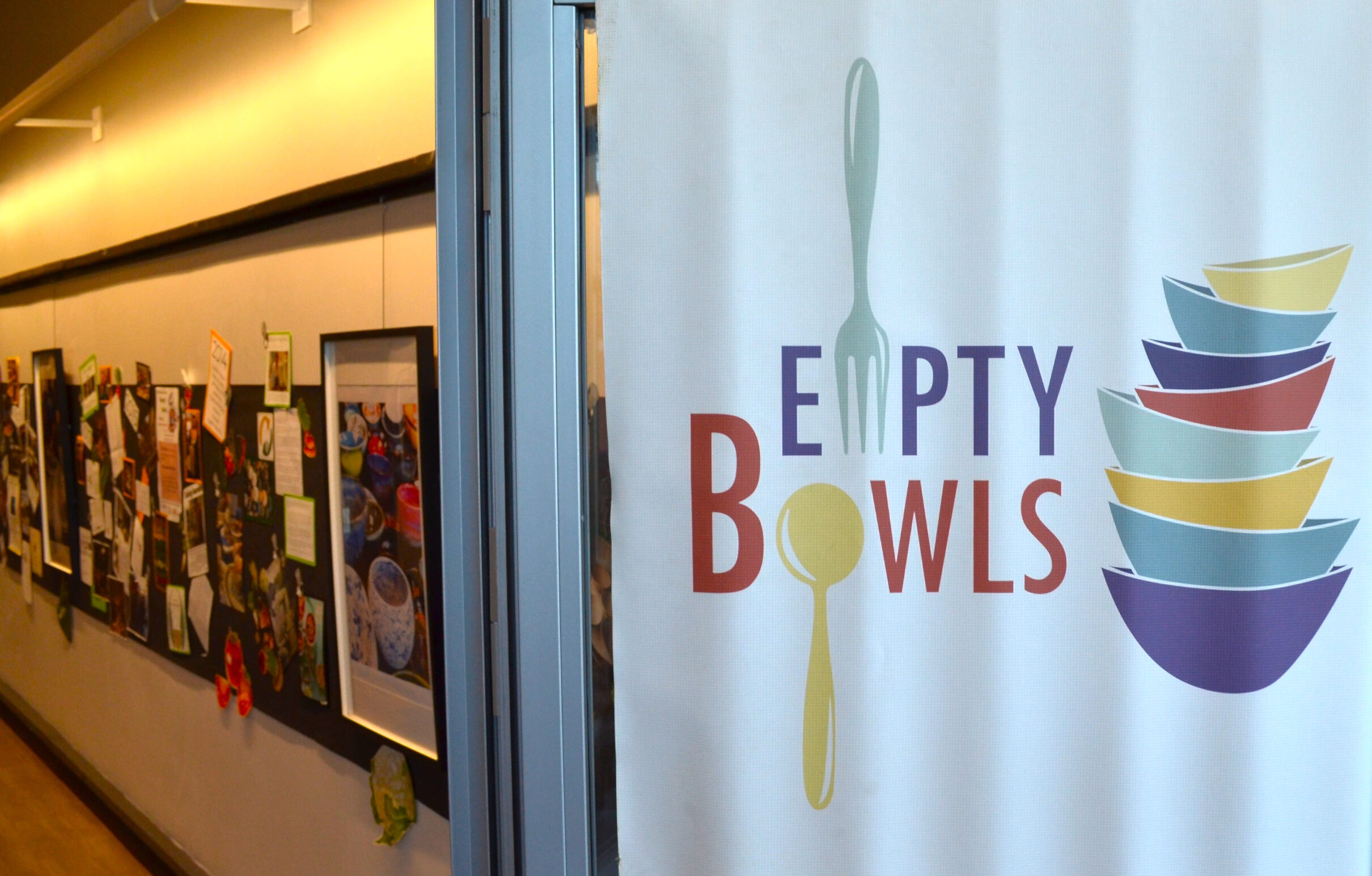Image shows the entrace door to the Jan Dempsey Arts Center with a large Empty Bowls sign on it.
