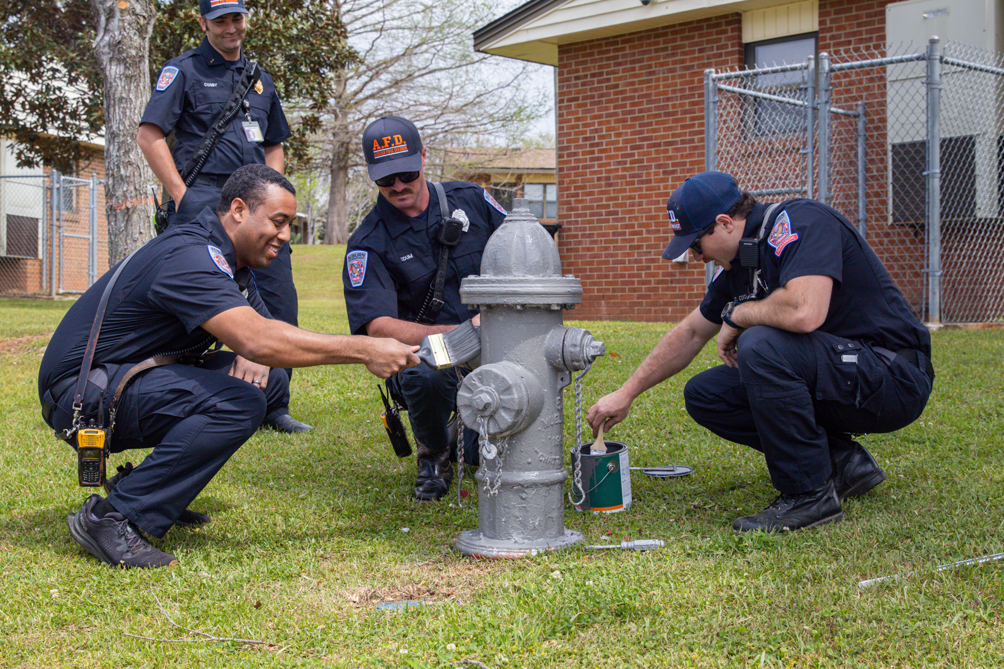 Firefighters painting a hydrant