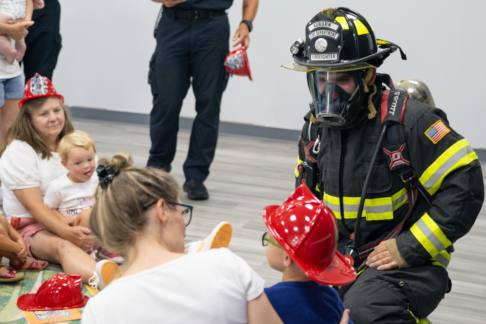 Firefigher in full gear greeting child