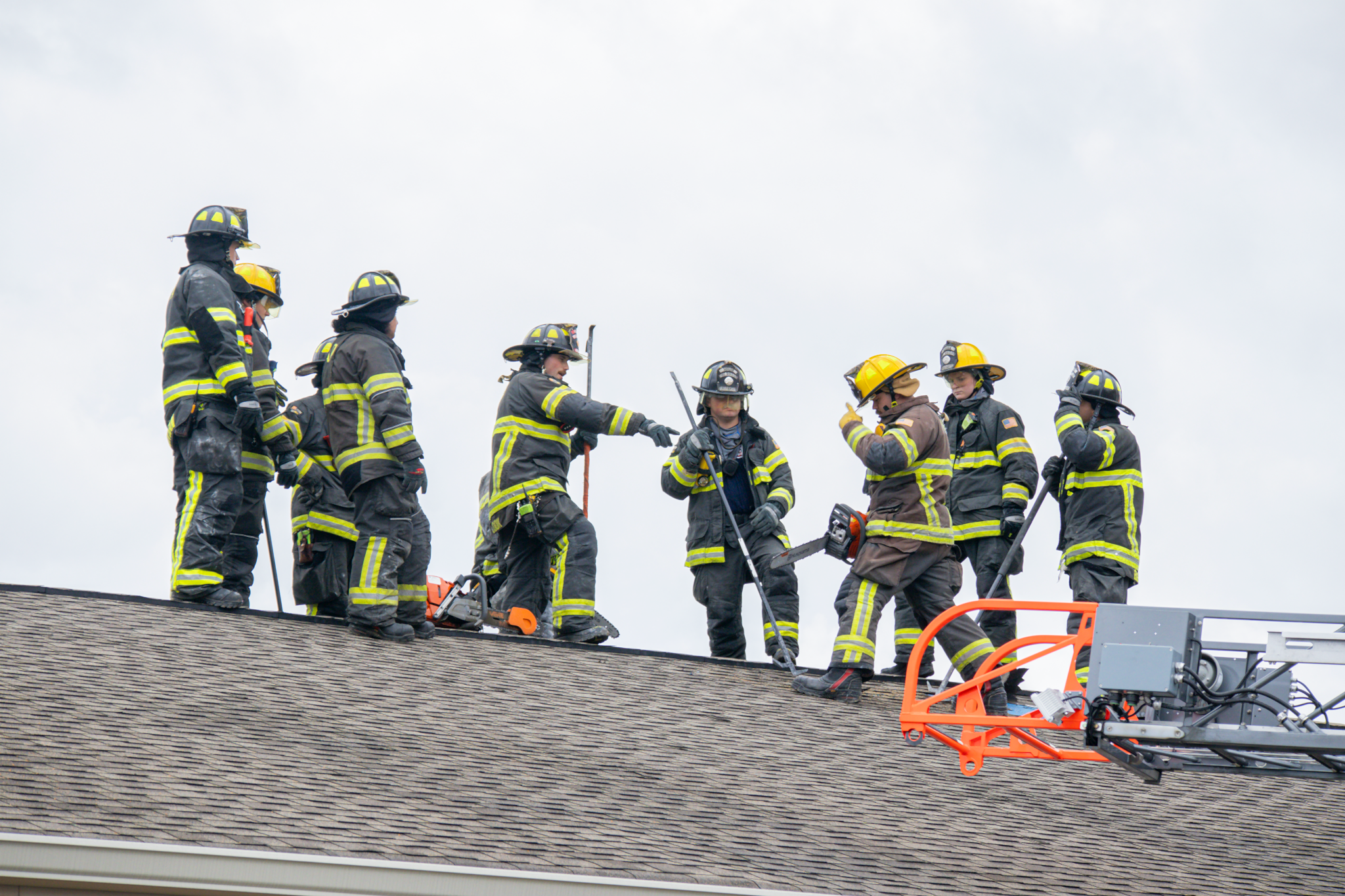Firefighters working together on roof