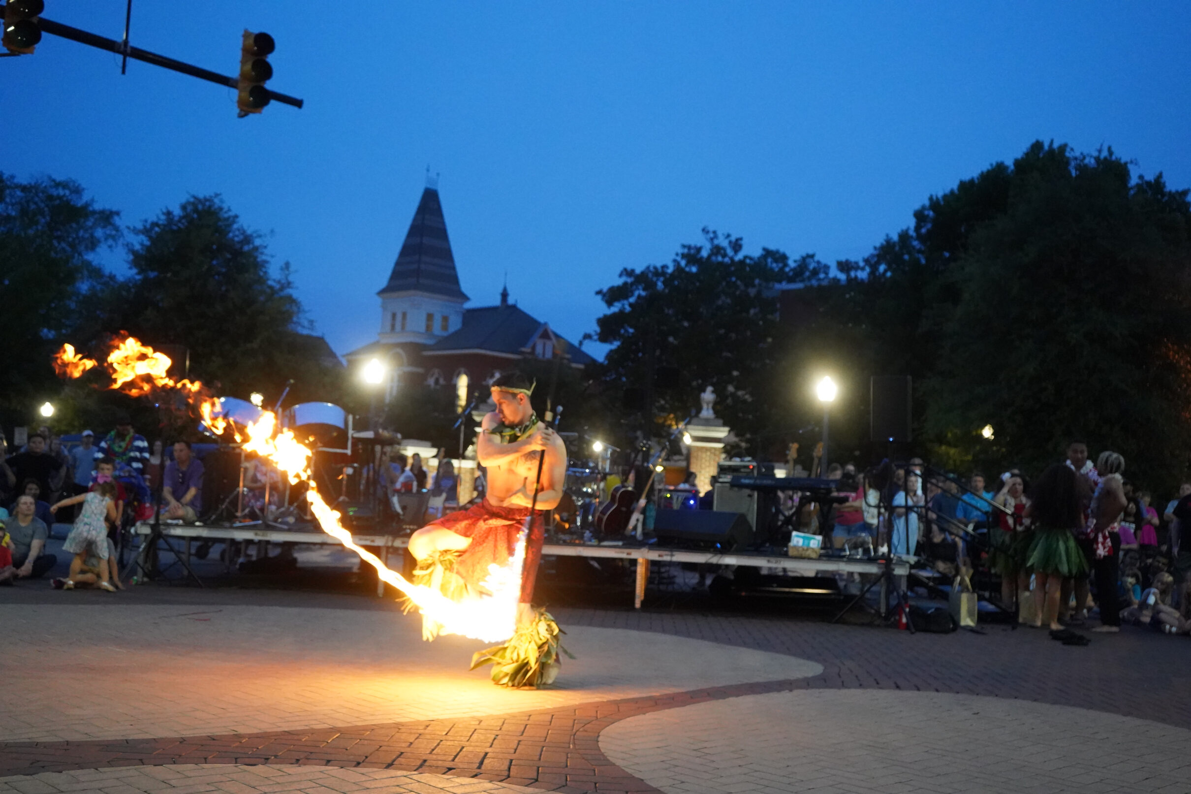 Image shows Hawaiian Dance male sprinning a fire flame.