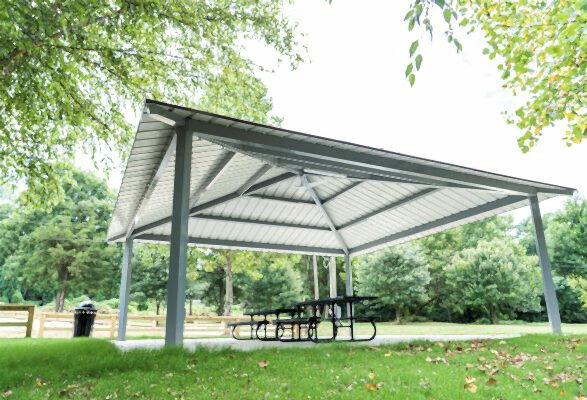 Pavilion with metal covering, picnic tables, and a trash can