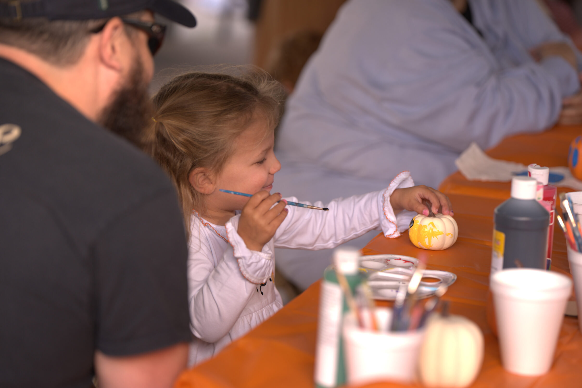 Little girl painting a pumpkin
