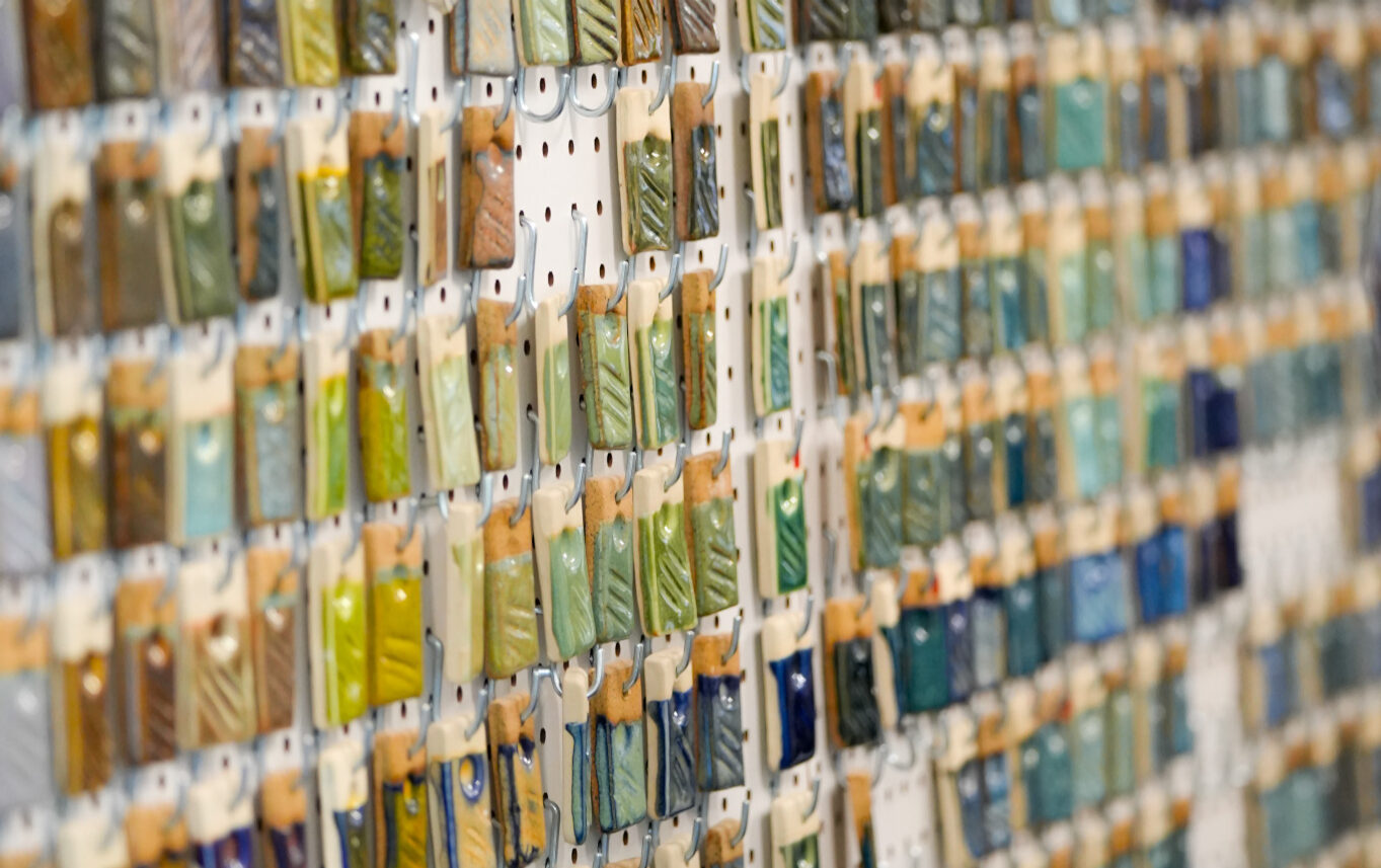 Wall displaying various ceramic galzes on tiles.