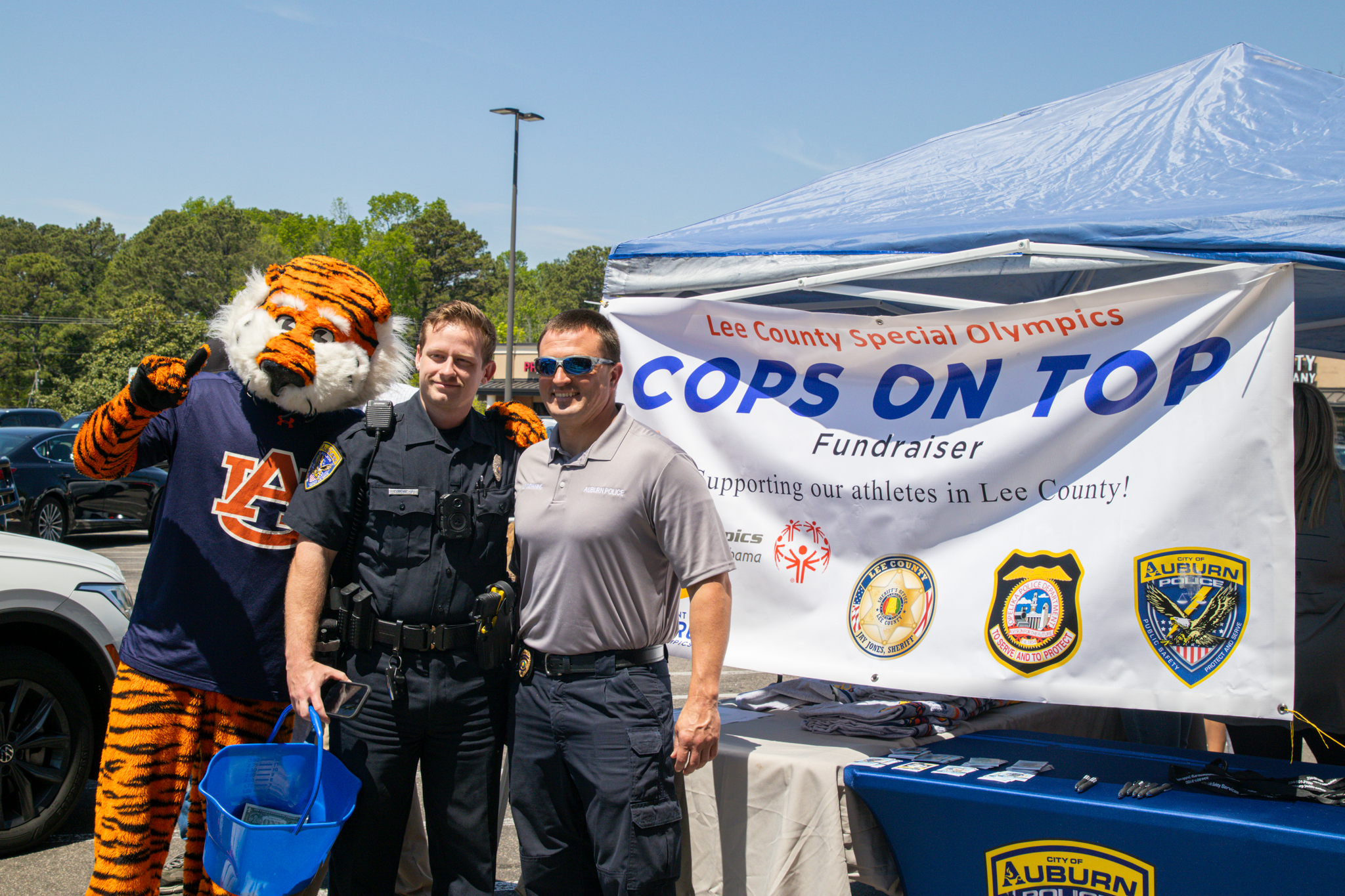 Aubie posing with two officers at Auburn Police Department's "Cops on Top" event