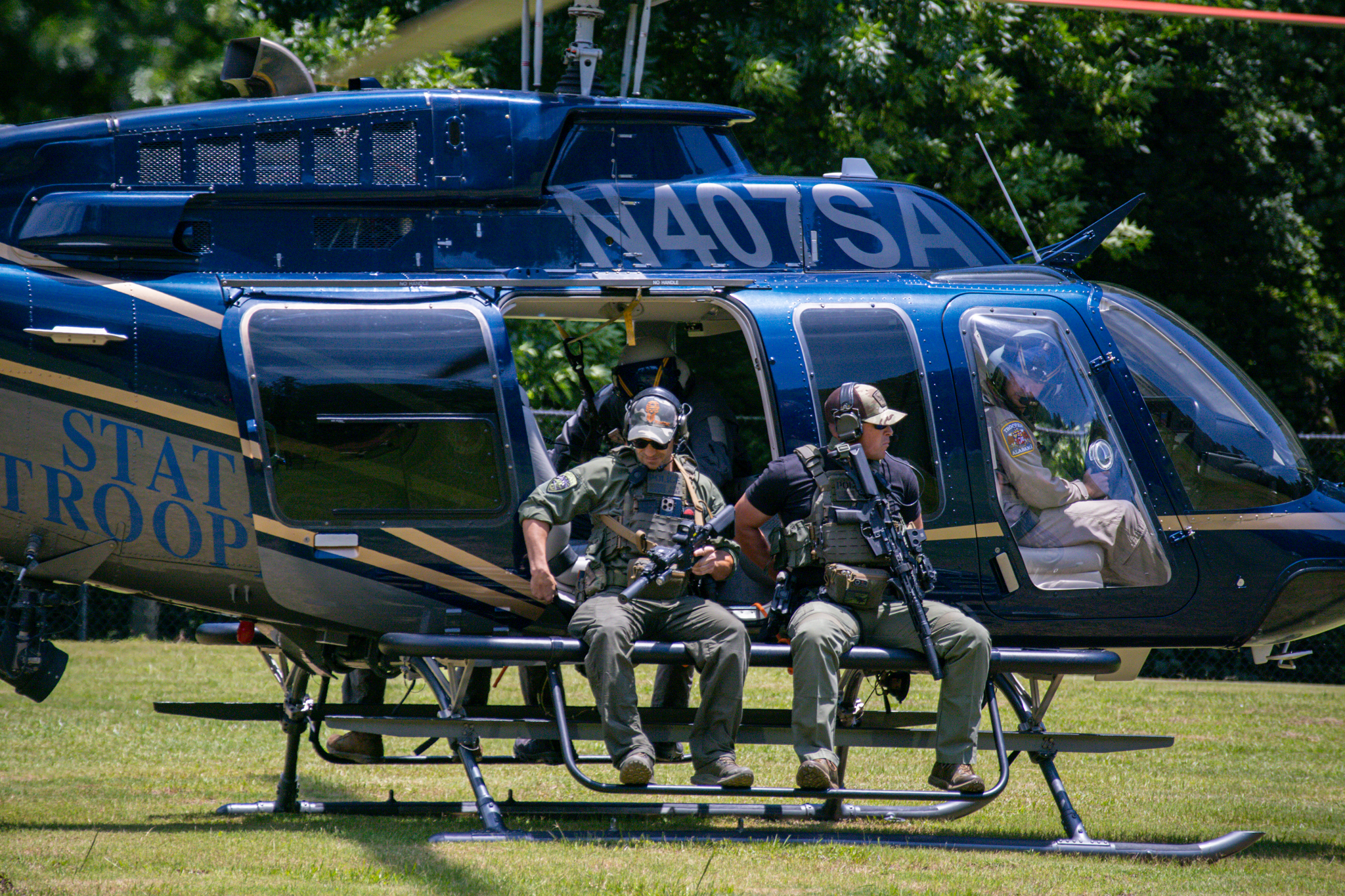 SWAT officers sitting on side of helicopter
